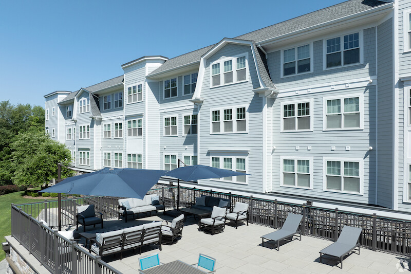 Furnished outdoor terrace with sectional seating and sun loungers