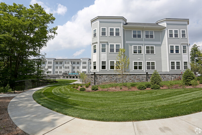 Rear building view with manicured lawn and curved walkway