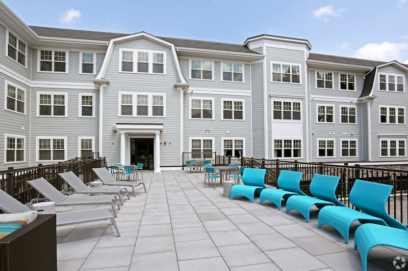 Outdoor patio with teal chaise lounges and bistro seating