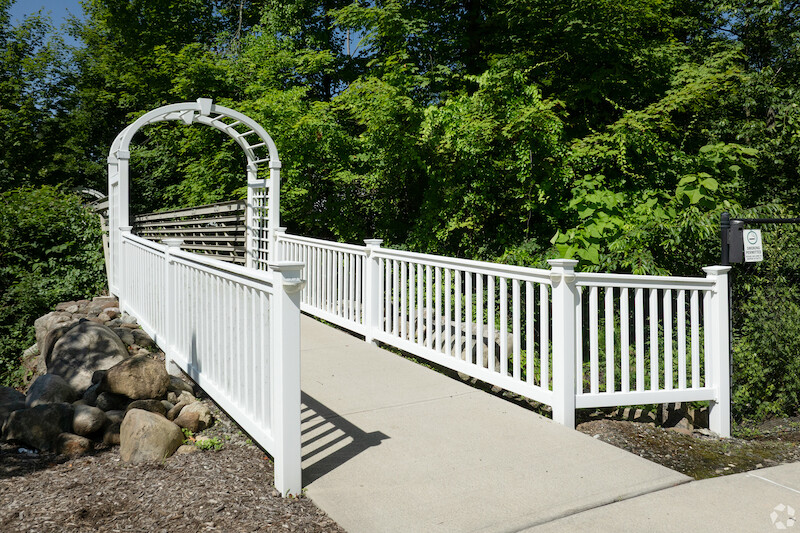 White trellis arbor walkway on landscaped grounds