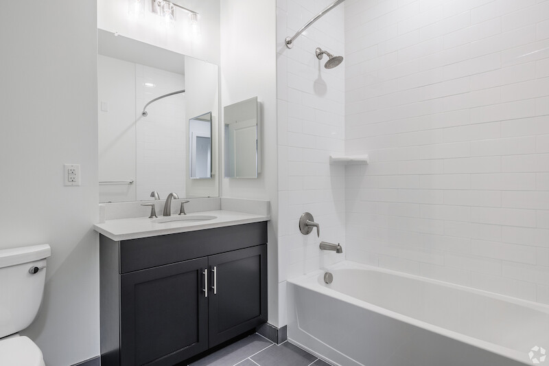 Bathroom with quartz vanity and glass-enclosed shower