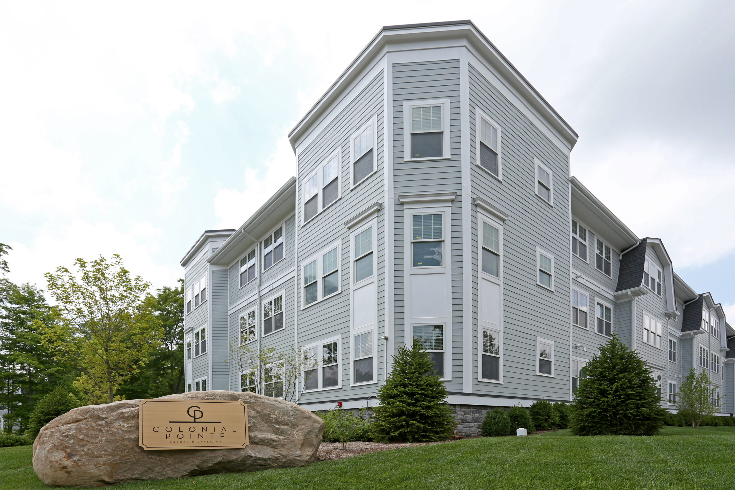 Colonial Pointe Luxury Plus building at 556 Colonial Road with stone monument sign and landscaped entrance